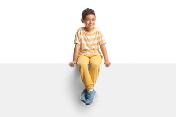 Asian boy sitting on a panel and looking at camera