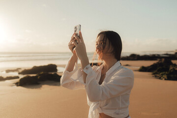 Young girl recording video on phone share via app her travel vacation near seaside. Gen Z influencer shooting social media stories. Concept of friendship between a dog and human. Part of a series. UGC