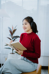 Naklejka premium Asian teenage girls are happily listening to music from headphone, Asian girls relax by listening to music in the home