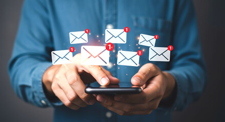 Person holding a smartphone with email notifications floating above the device in a digital display