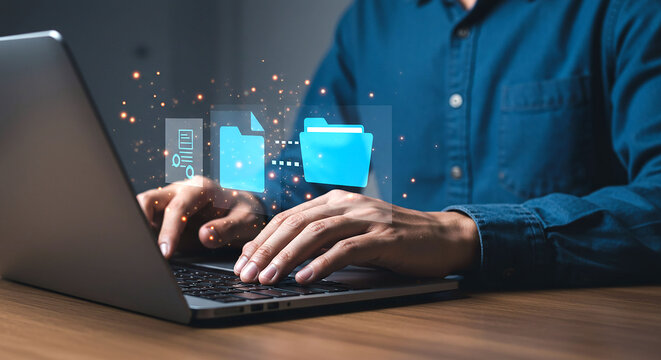 Person using laptop with digital file transfer icons above the keyboard on a wooden table top