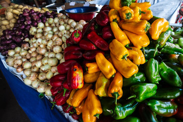 Vegetables, greens and legumes for sale at a street market counter.