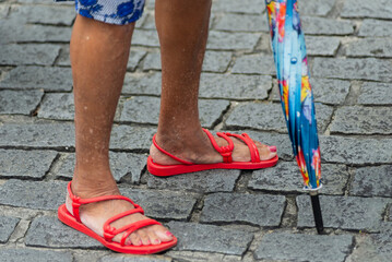 Half-body of unidentified people walking on the street wearing casual clothes.