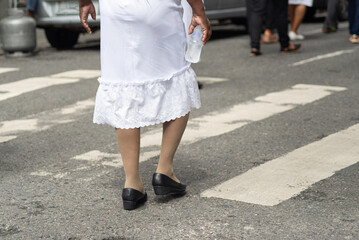 Half-body of unidentified people walking on the street wearing casual clothes.