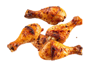 Four roasted chicken drumsticks falling on transparent background