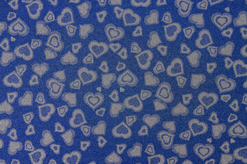 
Texture of paper with hearts. Decorative sheet of cardboard with hearts. Blue background with hearts