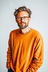 Fototapeta premium A man with glasses and a beard wearing an orange sweatshirt