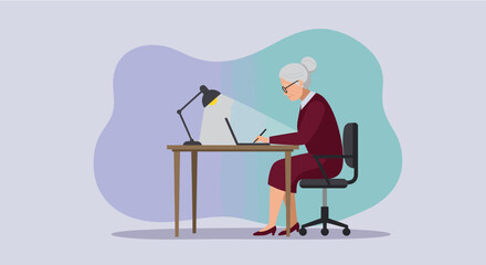 Elderly businesswoman working diligently on a laptop at her desk, illuminated by a desk lamp, in a modern office setting.