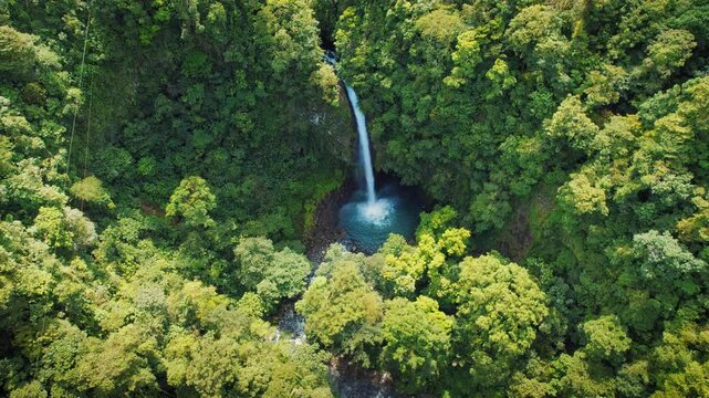 Aerial view of La Fortuna waterfall surrounded by lush tropical rainforest in Costa Rica