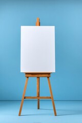 A wooden easel supports a blank white canvas against a light blue background
