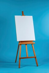 Wooden easel with a blank white canvas against a blue background