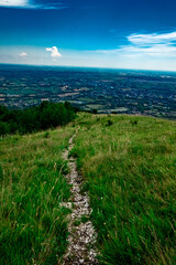 Stone Path on Grassy Hill Overlooking Valley – Tranquil Countryside View Under a Blue Sky