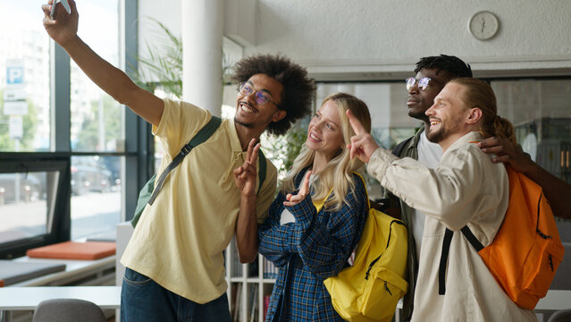 Multiracial students happy smiling diversity friends African men guys males Caucasian girl woman female high school university grimacing together selfie photo record video take picture mobile phone - Powered by Adobe