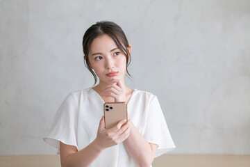 スマホを見て悩む女性