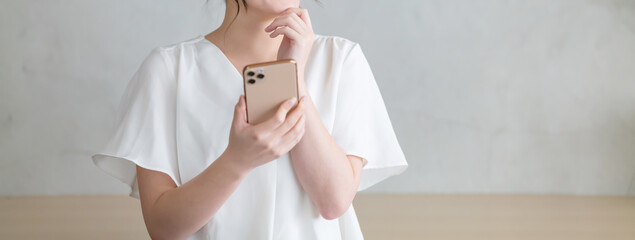スマホを見て悩む女性