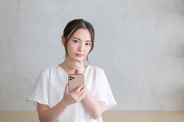 スマホを見て悩む女性
