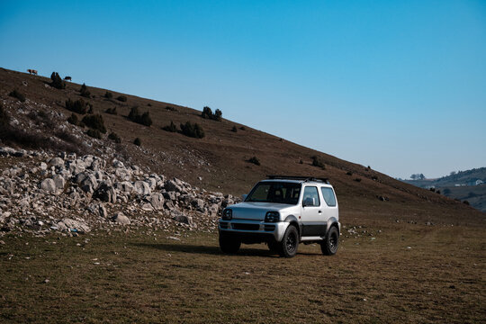 Silver off-road vehicle parked on mountain meadow exploring wilderness