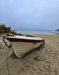 wonderful view of a boat in the foreground on the beach with a pier in the background