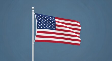 Obraz premium American Flag Waving on Flagpole Against Blue Sky