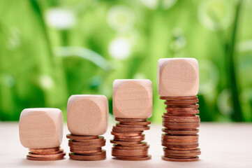 Coins stacked beside wooden blocks representing financial stability and sustainable development...
