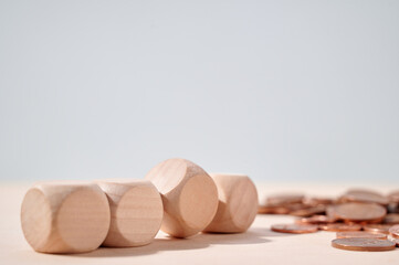 Wooden blocks and coins on neutral backdrop representing financial planning, savings, and...