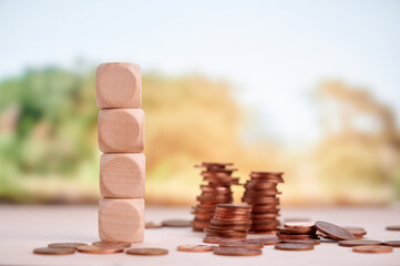 Wooden block tower and arranged coins showcasing financial planning, investment, and growth with...
