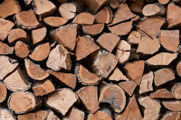  Lots of firewood stacked in a woodpile. Stove heating of a house.