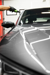 Exterior Car Drying with Compressed Air. High-pressure air is directed at tight vehicle seams to...