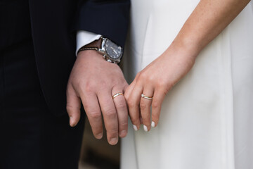 Married couple holding hands with rings ceremony wedding day