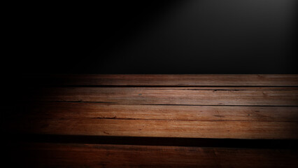 Light shines on empty wooden table with dark background. Top view of wooden surface for product...