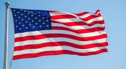 Fototapeta premium Majestic US Flag Flying Against a Clear Bright Blue Sky