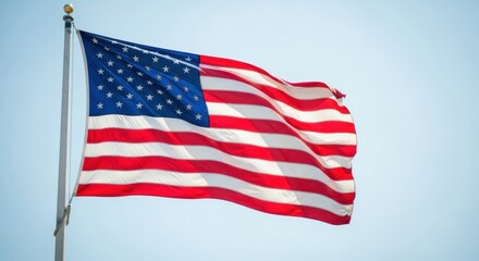 Obraz premium United States Flag Billowing in a Sunny, Light Blue Sky