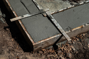 Freshly poured concrete foundation slab within wooden formwork. The concrete is in the early stages of setting.