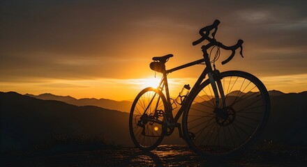 Obraz premium Bicycle Silhouette at Mountain Sunset for Adventure and Sport
