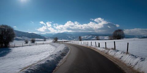 Serene winter landscape with snowy fields and curving road