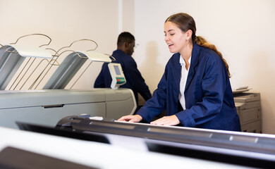 Female worker in a printing and press centar check the print quality