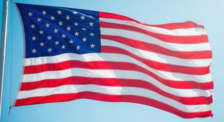 Obraz premium Sunlit American Flag Waving on a Clear Blue Sky