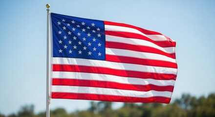 Obraz premium American Flag Waving Against a Clear Sky with Distant Trees