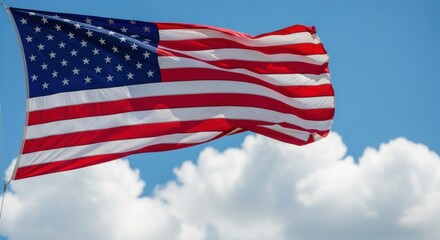 Obraz premium United States Flag Against a Bright Blue Sky with White Clouds