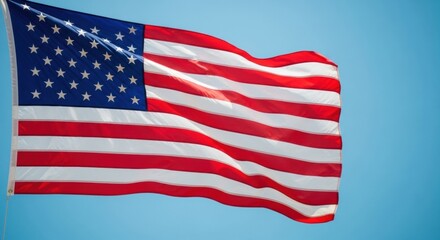 Fototapeta premium Dynamic American Flag Waving Against a Vibrant Blue Sky