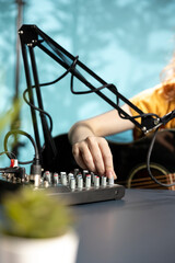 Artist filming DJ mixing tutorial, showing examples of sampling on sound controller to audience....