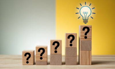 Ideas and Questions concept with wooden blocks and light bulb