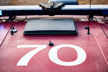 Engine 70 - Large number 70 printed on the top of a fire engine with blue lights flashing. 