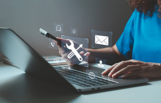Woman using laptop and smartphone to access technical support services with virtual icons of tools, email, chat, global network, and 24/7 online client assistance for business solutions. AI help desk.