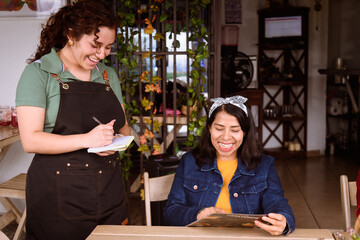 Woman asking the waitress for her order in a restaurant