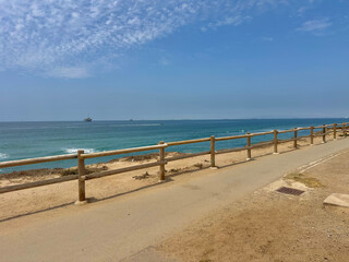Wide view of a sunny beach coastline on a bright summer day in June in Huntington Beach, SoCal, Southern California, USA