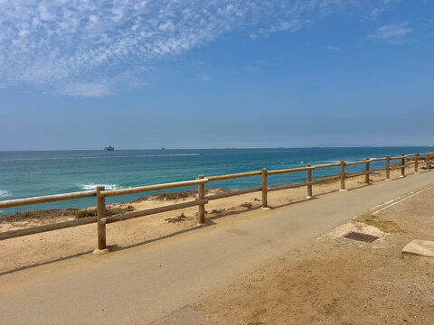 Wide view of a sunny beach coastline on a bright summer day in June in Huntington Beach, SoCal, Southern California, USA