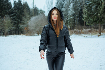 In a magical Winter Wonderland, a stylishly dressed woman joyfully embraces the snowcovered...
