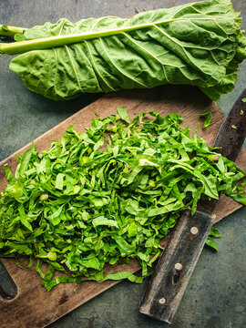 Brassica oleracea leaves, green cabbage cut chiffonade on rustic wooden board 
