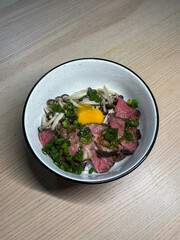 Rice bowl topped with sliced beef and mushroom.